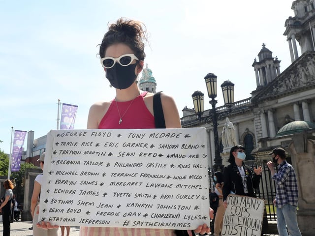 A protester holds a placard listing some of the most recent black men and women to be killed by police in the USA.