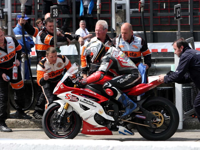 Michael Dunlop is pushed away on his Yamaha by sponsor Gary Ryan after making his pit-stop in the second Supersport race at the Isle of Man TT in 2000.