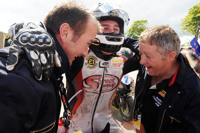 A jubilant Michael Dunlop celebrates his first TT success with sponsors Gary Ryan (left) and Martin Marlow.