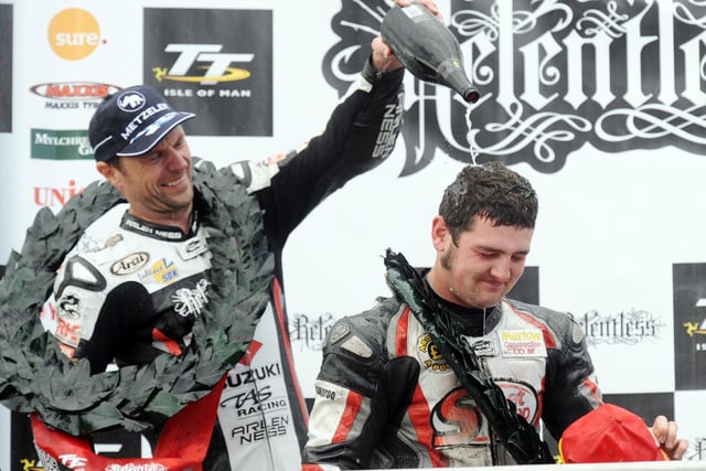Runner-up Bruce Anstey soaks race winner Michael Dunlop with champagne on the TT rostrum.