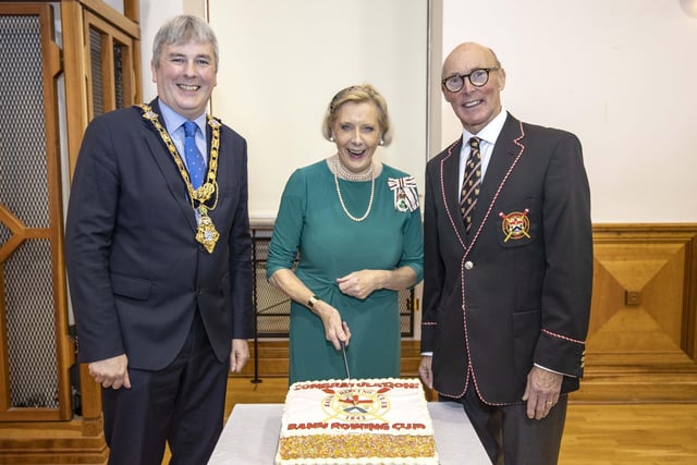 Lord-Lieutenant for County Londonderry Alison Millar cuts a special cake to mark the presentation of the Queen’s Award for Voluntary Service to Bann Rowing Club alongside the Mayor of Causeway Coast and Glens Borough Council Councillor Richard Holmes and Bann Rowing Club Captain Keith Leighton