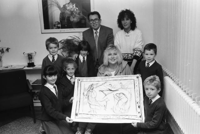 Mhairi Sutherland showing a sketch drawing of one of a proposed mural at Holy Child P.S. to pupils. From left, Kathleen Commander, Michael Deane, Kerry Moran, Paula Carlin, Sean Barr and Paul Loughrey. At back are, Mr. Charles O’Donnell, principal, and Mrs. Eileen Devine, Creggan Visual Arts Committee.