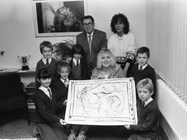 Mhairi Sutherland showing a sketch drawing of one of a proposed mural at Holy Child P.S. to pupils. From left, Kathleen Commander, Michael Deane, Kerry Moran, Paula Carlin, Sean Barr and Paul Loughrey. At back are, Mr. Charles O’Donnell, principal, and Mrs. Eileen Devine, Creggan Visual Arts Committee.