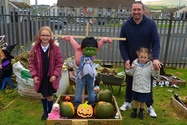 Bunscoil Cholmcille pupils Freya and Leia pictured with their dad Chris at the judging of the school’s Halloween plant beds competition on Monday afternoon last. DER2143GS – 035