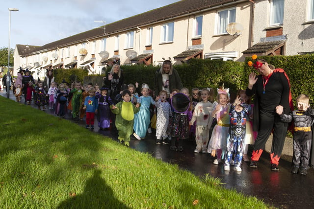 Some of the P1 pupils, teachers and classroom assistants from Greenhaw PS take time to wave to the camera during Fridayâ€TMs Halloween Walkabout around Carnhill (Photos: Jim McCafferty Photography)