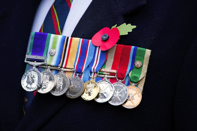 A row of medals and a memorial poppy worn by a man attending the funeral of Dennis Hutchings, who died after contracting Covid-19 while he was in Belfast to face trial over a fatal shooting incident in Co Tyrone in 1974, at St Andrew's Church in Plymouth. Picture date: Thursday November 11, 2021.