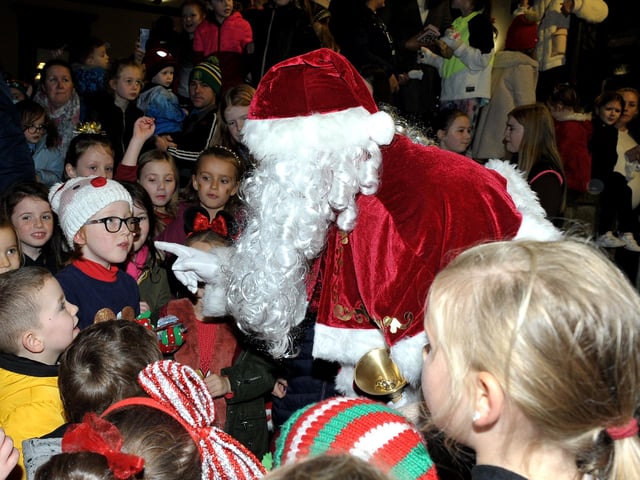 Santa greets children at the switching on of the Christmas tree lights in Buncrana on Friday evening last. Photo: George Sweeney.  DER2146GS – 041