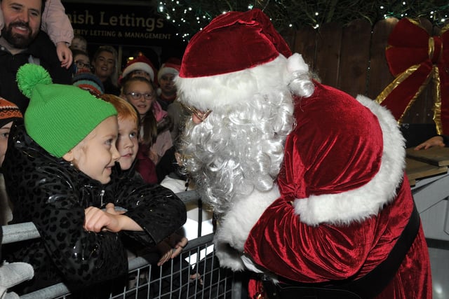 Santa greets children at the switching on of the Christmas tree lights in Buncrana on Friday evening last. Photo: George Sweeney.  DER2146GS – 040