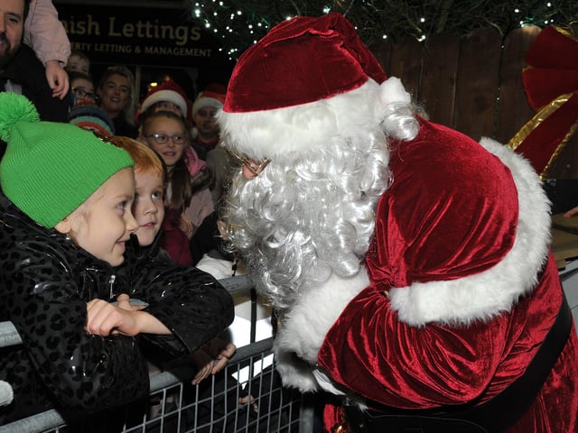 Santa greets children at the switching on of the Christmas tree lights in Buncrana on Friday evening last. Photo: George Sweeney.  DER2146GS – 040