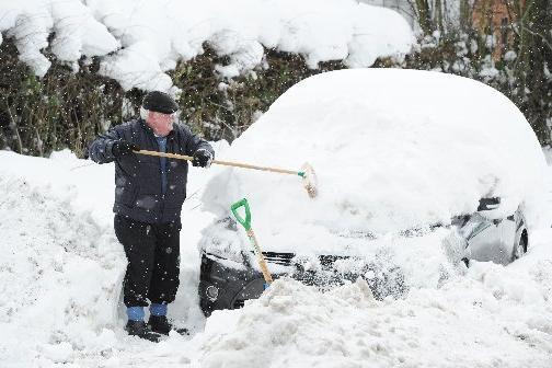 A man clears snow off his car in the 'big freeze' in 2010.