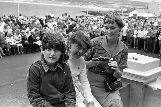 Nine-year-old Penny Winter from the Malone Road, Belfast, Lesley Anne Smith, 9, and Mrs Trudy Smith, Cranmore Park, Belfast, wait to photograph members of the British Legion on parade in Portrush in September 1981. Picture: News Letter archives