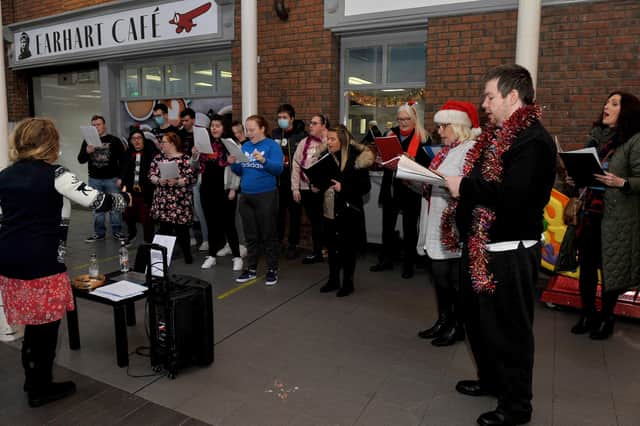 IN FINE VOICE... The Calms Choir, and the HUB choir from the Liberty Consortium HUB facility at Northside Village Centre, entertain shoppers with Christmas carols on Wednesday morning last. DER2148GS – 013