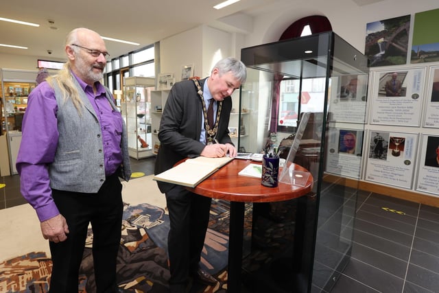 The Mayor of Causeway Coast and Glens Borough Council, Councillor Richard Holmes signs the visitors’ book at the opening of the NI100 - Influencers from the Roe Valley’ Exhibition with Matthew Ferguson from Roe Valley Ancestral Researcher