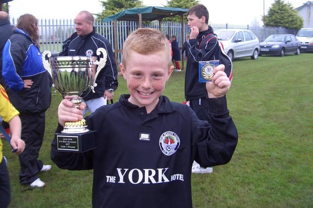 ALL SMILES....Glen Law pictured with the cup and medal which the Bertie Peacock Youths under 11's won at a tournament in Larne on Saturday. CR27-359(s)