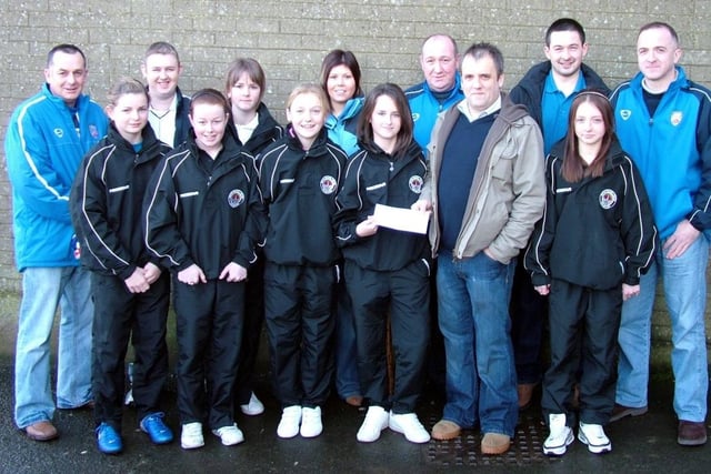 Adrian Bovaird of the Bannsiders Supporters' Club presents a sponsorship cheque to Lisa McNeill of the Bertie Peacock's Youths Girls team. Also included are the other team members, their coach Nichola Forgrave and members of the Supporters' Club.CR1-268s