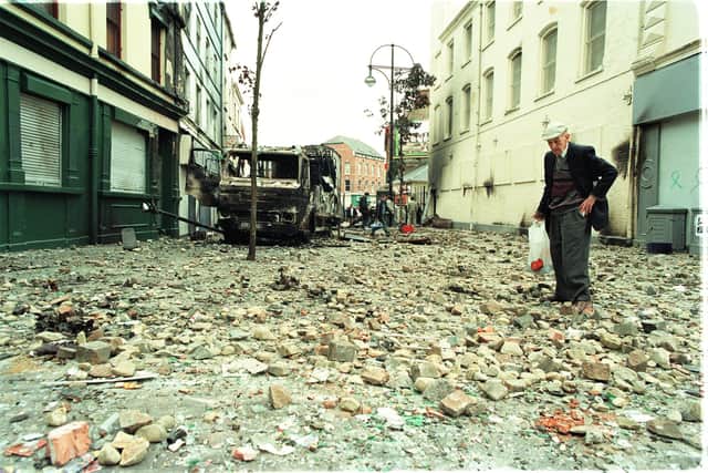 July 1997... A man negotiates his way through a brick-strewn William Street, scene of rioting the previous night after an Orange Order parade was allowed to walk down the nationalist Garvaghy Road in Portadown.