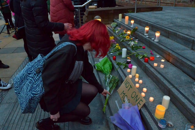 A student at the vigil for Ashling Murphy places flowers on the Guildhall Steps on Friday afternoon. Photo: George Sweeney.  DER2202GS – 099