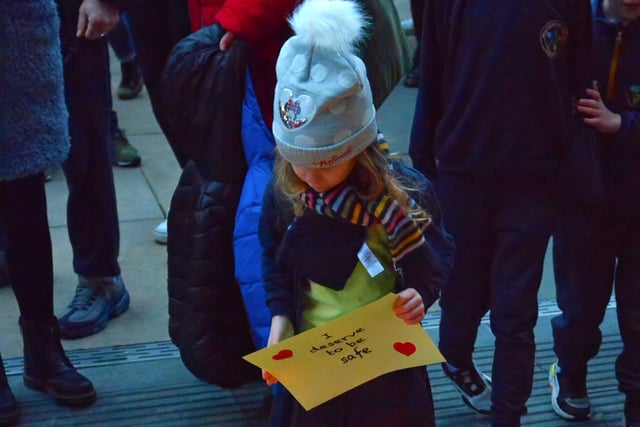 A young girl attending the vigil for Ashling Murphy places a message on the Guildhall Steps on Friday afternoon. Photo: George Sweeney.  DER2202GS – 082
