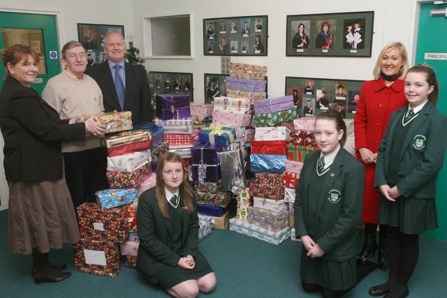 Briege Lewis, teacher and charity co-ordinator, handing over Christmas parcels collected by pupils at St.Cecilia's College,  to Harry Baldrick and Lyle Simpson, with The Eschol Trust, for the Children of Bulgaria  'Shoebox' appeal. Included are college principal Kathleen Gormley and pupils Temair Hamilton, Eimhear O'Neill and Stephanie Curtis.  (1912T11).