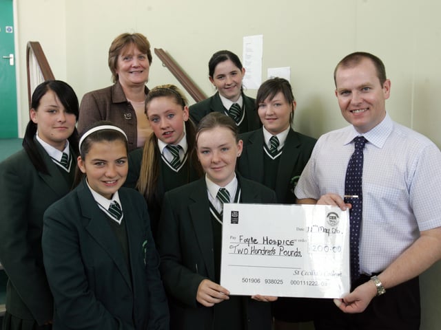 Pupils from Class 10 A at St. Cecilia's College, presenting a cheque, proceeds of a charity ice-cream parlour, to Ciaran McGinley, Foyle Hospice. Included are Nadine Boyle, Jeanine Campbell, Caitlin Archibald, Naomi Ferguson, Jacquleine Dunne, Catriona Thornton, and Ms. Carol Hutahaean, classroom assistant. (3006C02)