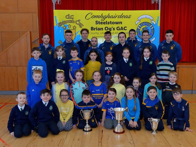 St Patrick’s PS Pennyburn P4 pupils pictured with Steelstown Brian Og’s players Neil Forester, captain, Morgan Murray, Donncha Gilmore, Garth Logue, Jason McAleer, Ciarán Flanaghan, Eoghan Heraghty, Dermot McBride, coach, and Ben McCarron on Friday morning last. Photo: George Sweeney. DER2208GS – 076