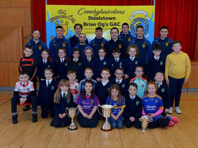 St Patrick’s PS Pennyburn P4 pupils pictured with Steelstown Brian Og’s players Neil Forester, captain, Morgan Murray, Donncha Gilmore, Garth Logue, Jason McAleer, Ciarán Flanaghan, Eoghan Heraghty, Dermot McBride, coach, and Ben McCarron on Friday morning last. Photo: George Sweeney. DER2208GS – 077