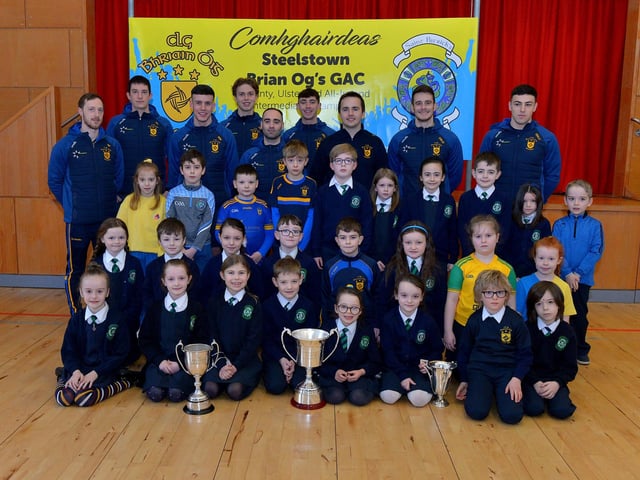 St Patrick’s PS Pennyburn P4 pupils pictured with Steelstown Brian Og’s players Neil Forester, captain, Eoghan Heraghty, Morgan Murray, Donncha Gilmore, Garth Logue, Jason McAleer, Ciaran Flanaghan, Dermot McBride, coach, and Ben McCarron on Friday morning last. Photo: George Sweeney. DER2208GS – 075