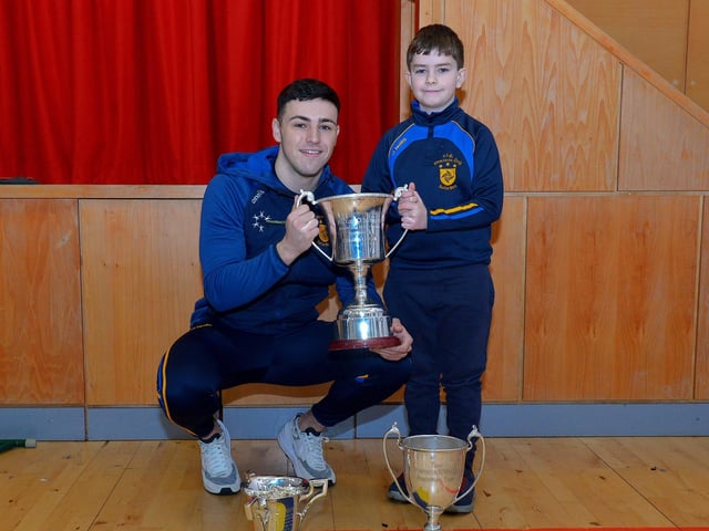 St Patrick’s PS Pennyburn P4 pupil Harry McCarron pictured with his cousin Steelstown and Derry county player Ben McCarron during a visit by Brian Og’s to the school on Friday morning last. Photo: George Sweeney. DER2208GS – 079