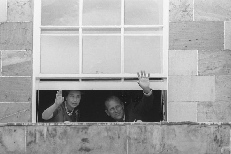 The Queen and Duke of Edinburgh wave to the cheering crowds from a window in Hillsborough Castle - 14 miles from Belfast - on the first day of their two-day Silver Jubilee visit to Ulster.