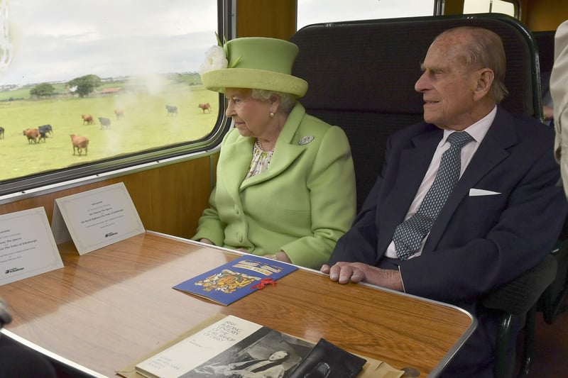 Queen Elizabeth II and the her husband, the Duke of Edinburgh travel by steam train along the North Antrim coast from Coleraine to Bellarena, during the second day of her visit to Northern Ireland to mark her 90th birthday.