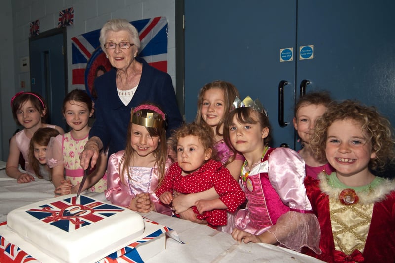 Mrs Lillian Sturdy, one of Ballycarry's oldest residents in April 2011, with her young assistants, cutting a cake to celebrate the Royal wedding of Prince William and Kate Middleton.  INLT 18-770-BM