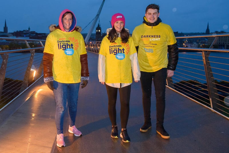 One Sunrise Together, Sarah Louise Temple, Fiona Temple and Jason Earley, pictured on the Peace Bridge in Derry during the Pieta Darkness Into Light 2021 sunrise walk supported by Electric Ireland. Thousands of people across Ireland joined together, while apart, under one sunrise on Saturday morning to offer hope to those impacted by suicide and to raise vital funds to ensure Pieta and its partner Northern Ireland charities can continue to provide their life-saving services.