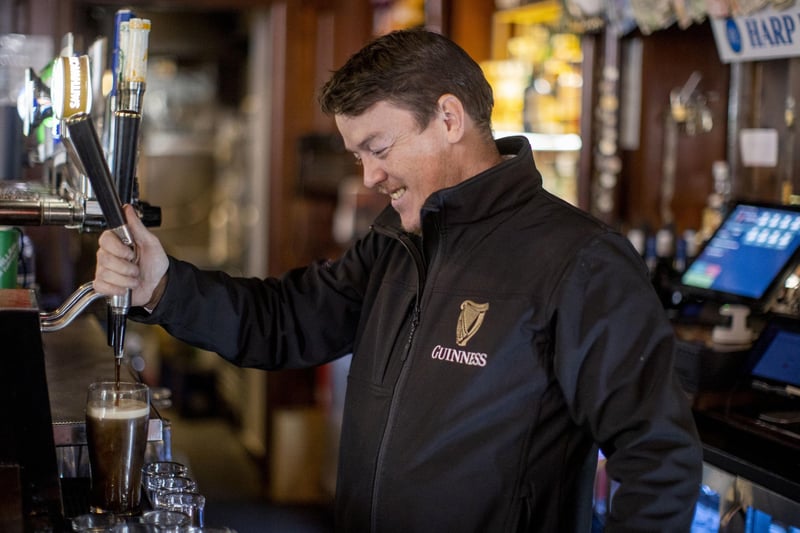 Liam Dawson, manager of The Garrick Bar in Belfast pouring a pint of Guinness after the latest easing of the Covid-19 rules in Northern Ireland