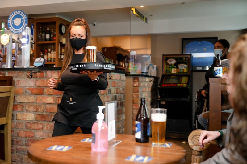 Sinead from Dan's Bar on the Springfield Road serves up the first pint of the day.

Picture: Philip Magowan / PressEye