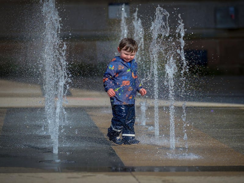 Dahir McBrien, aged 2, has fun in the water fountains, in Guildhall Square, during the Bank Holiday weekend. Photo: George Sweeney / Derry Journal. DER2117GS - 056