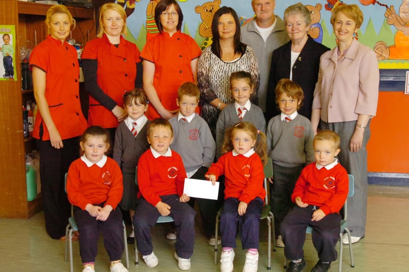 Children from Holy Family Primary School P1 class and Nursery who have taken part in a fun fitness event and organised a raffle present a cheque for £650 to Sister Ann, second right, and Gerry Deeney, fundraiser, which will go to help children attending the Sacred Heart Primary School in Bareilly, India. Included, front from left, Ellie Sharkey, Che-Eoin Temple, Amber Masterson and Daniel McDaid. Middle row, from left, Enya McDermott, Adam McLaughlin, Jane Houston and Regan McCaul. Back row, from left, Lisa Quinn, Michaela Robinson, Sonia Harkin, Linda Parke, teacher, and Catherine Donaghey, vice principal. (2706PG03)