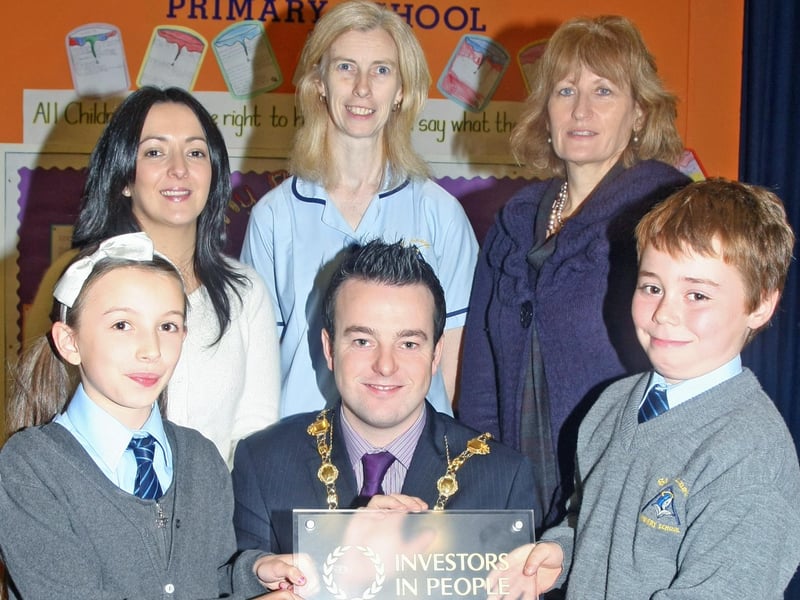 The Mayor of Derry, Colr. Colum Eastwood presents St. Anne's PS, Rosemount, pupils Jodie Cooley and Sean Ball with the Investors In People Champion Status Award at the school on Tuesday. The school is one of only seven organisations in Northern Ireland to have achieved Champion Status. Back from left are, Oonagh Callan, teacher, Aisling Holmes, Learning Support Assistant and Jacinta Bradley, Principal, St. Anne's PS. 2910JM02