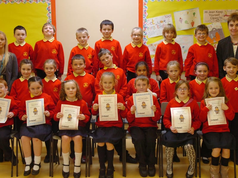 P4 pupils from Steelstown Primary School receive certificates for completing the Primary Attendance Matters programme. Included are Aine Doherty, left, education welfare officer, and Jacinta Hegarty, teacher. (2910PG04)