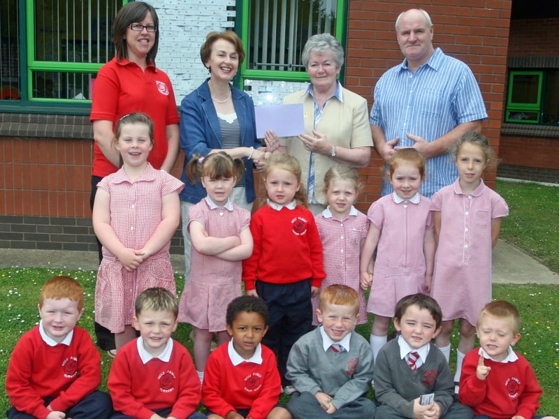 Mrs. Catherine Donaghy, vice principal, Holy Family PS, presents a cheque for £1,550 to Sister Ann Doherty and Gerry Deeney, proceeds of which will be sent to Sacred Heart PS, Bareilly, India to help maintain the school there. The monies were raised by four classes of nursery and P1 pupils from the school through a sponsored fun fitness day. Back on left is Sonia Harkin, nursery assistant. 2906JM45