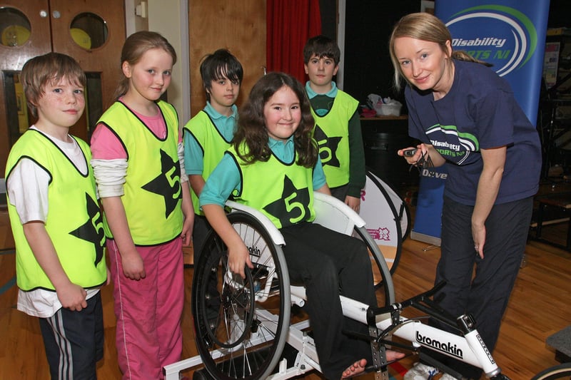 Joanne O’Hagan, with Disability Sport NI, keeping time as Oakgrove Integrated PS pupils (from left), James Sandrey, Jennifer Hamilton, Peter Vella, Joshua Patton and Amber Thompson, take part in a wheelchair race at the Disability Sports Challenge, held  at the school.  INLS 5010-506MT.