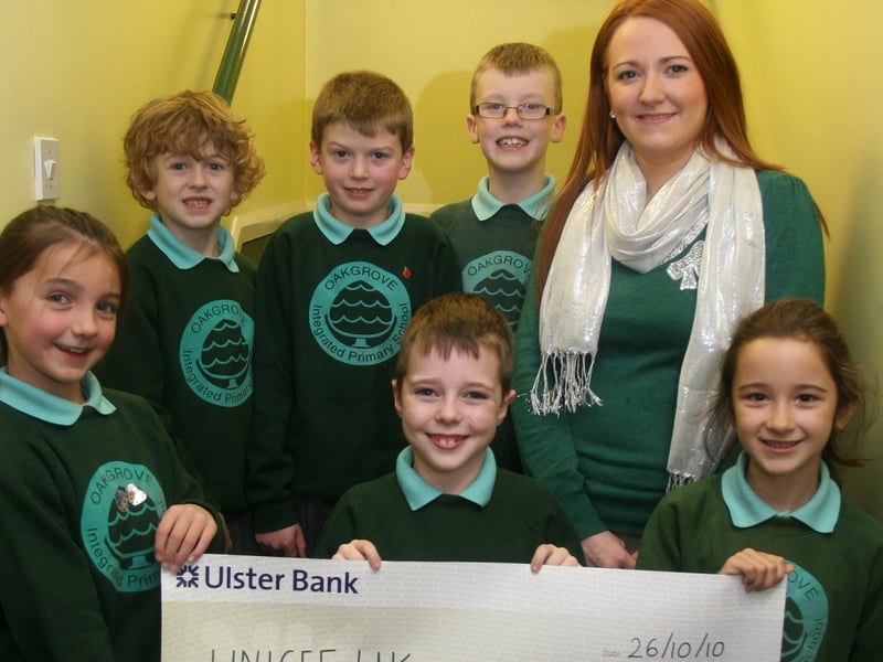 Oakgrove PS, Waterside P4/5 pupils pictured with a cheque for UNICEF UK for £1,062.72, proceeds of a 'Silver Coin Line' competition held in the school in aid of the Pakistan Emergency Flood Appeal. Front from left, Deirbhile Herron, Ryan Kyle and Emma Borland. Back from left, James Cochran, Conor Bratton, Evan Stanley and Miss Louise-Anne Quinn, teacher. 1211JM30