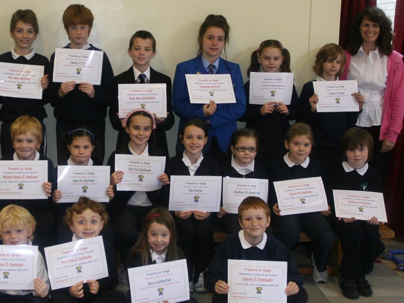 Pupils, past and present, from Bunscoil Cholmcille, Steelstown who received certificates of attendance at the school on Thursday morning. On left is Aine Hudson, Education Welfare Officer, who presented the awards and, on right, Caroline Mhic Colla, teacher. 1510JM33