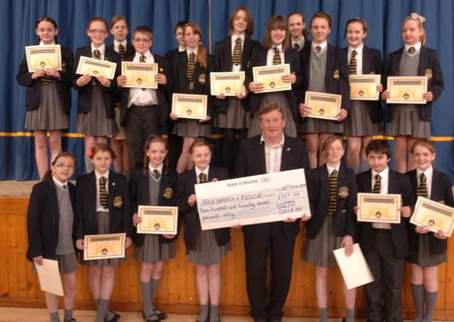Pupils from Lumen christi college presenting a cheque for £327 to Danny Kelly, Foyle search and rescue the proceeds of a young enterprise project at the school. (2806SL08)