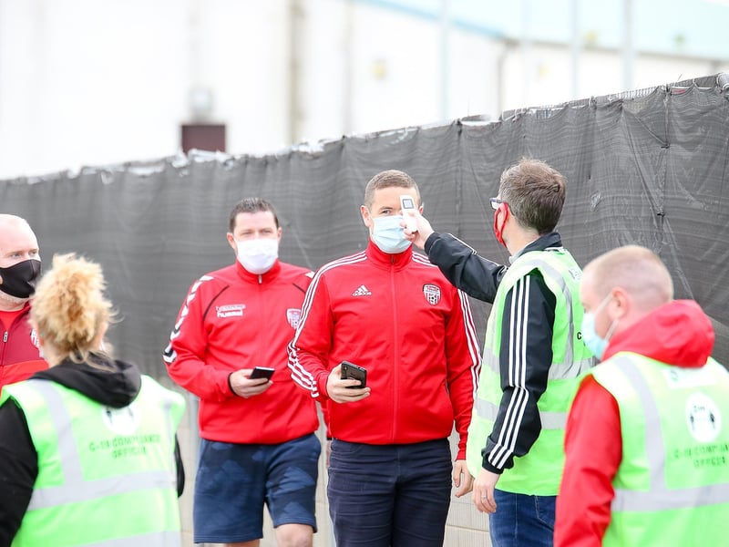 This group of Derry fans are armed with their e-tickets as they wait to get their temperatures checked at the gate.