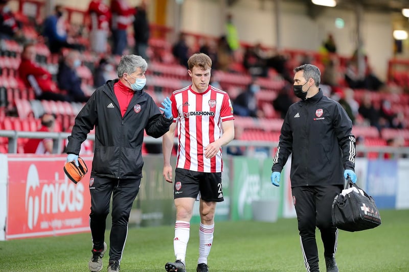 Derry City fans applaud defender Cameron McJannet as he's walked off the pitch by the Candy Stripes medical team.