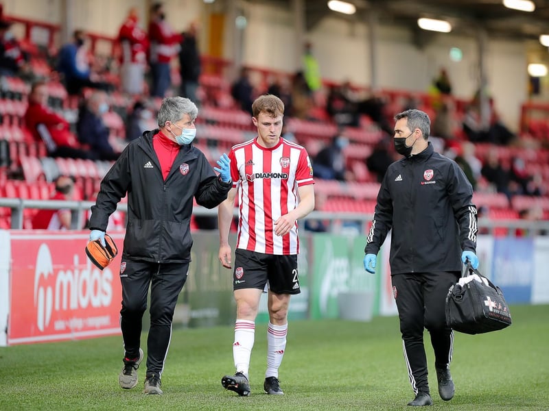Derry City fans applaud defender Cameron McJannet as he's walked off the pitch by the Candy Stripes medical team.