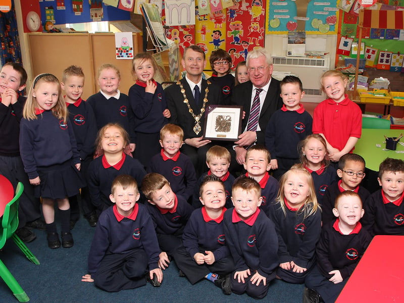 The Mayor of Derry Alderman Maurice Devenney, on his courtesy visit to St. Oliver Plunkett primary school, Strathfoyle, presents a specially designed civic gift to the principal Brian McLaughlin. Included in the picture are pupils from class P1.