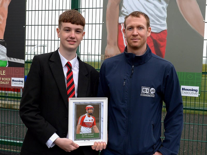 Tiarnan Quigley, St Brigid’s College, presents Na Magha’s Alan Grant with a photograph of Alan’s sporting hero mural on display at the Leafair Well-Being Village. DER2125GS - 025
