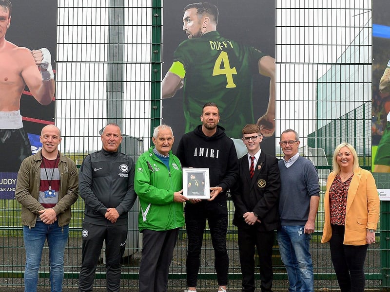 Gerry Doherty presents Shane Duffy with a photograph of Shane’s sporting hero mural on display at the Leafair Well-Being Village. Included in the photograph are John Ferry, NIHE, Leroy McCourt, Oisin McCartney , Eddie Breslin, NIHE, project sponsor and Karen Mullan MLA. Photos: George Sweeney / Derry Journal DER2125GS - 022