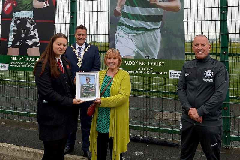 Celine McCourt receives a photograph of her son Paddy McCourt’s sporting hero mural on display at the Leafair Well-Being Village from St Brigid's College pupil Jenna Patton. Included in the photograph are Leroy McCourt and the Mayor of Derry and Strabane Alderman Graham Warke.  DER2125GS - 019